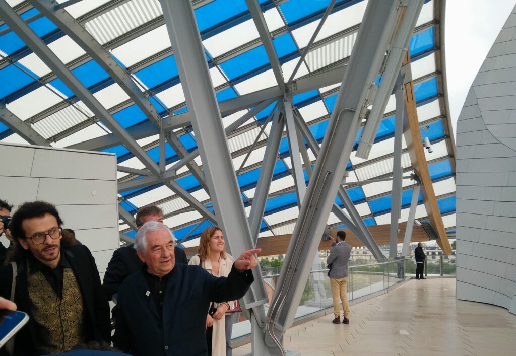 Daniel Buren et son galeriste pointent un détail du bâtiment de la Fondation Louis Vuitton